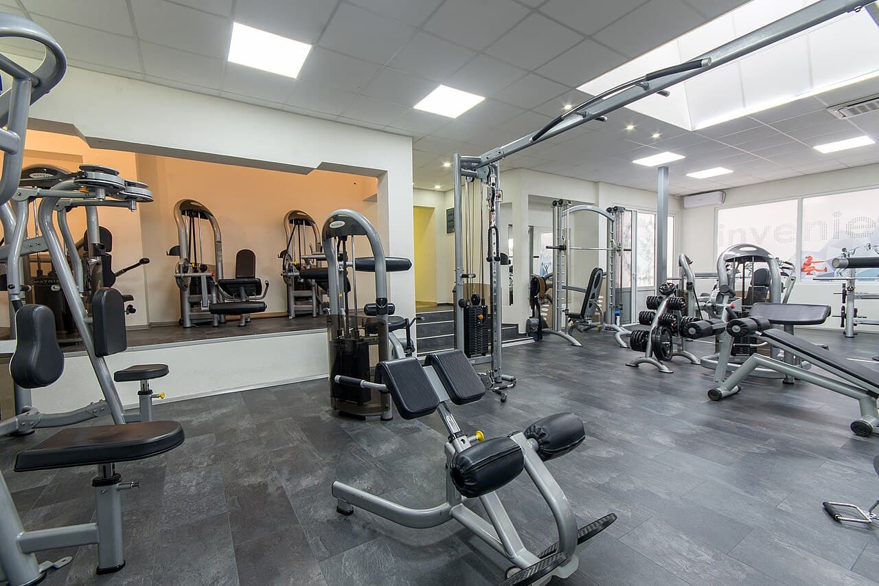 Modern gym interior with strength training and cardio equipment, managed with AnthroGym gym management software
